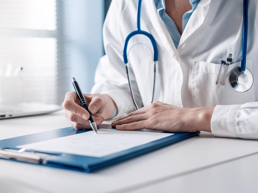 A health professional writing on a clipboard